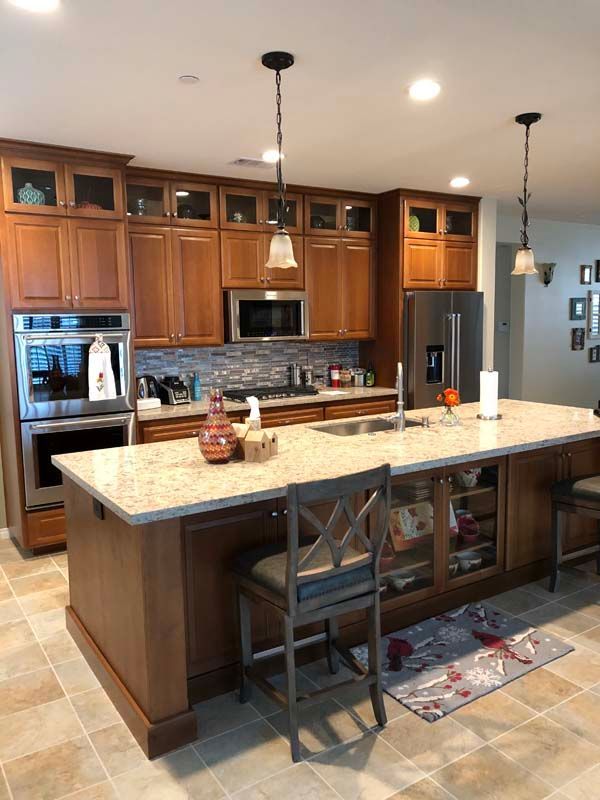 Spacious kitchen with wood cabinets, island, stainless steel appliances, and a granite countertop.