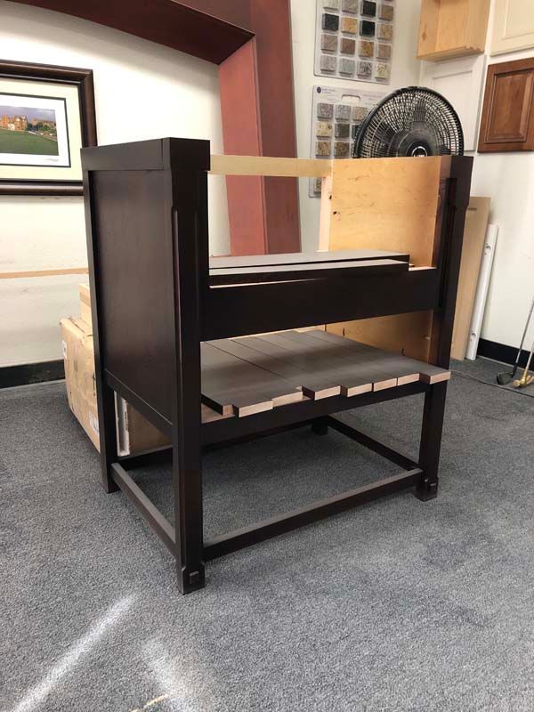 Dark brown wooden cabinet in a workshop, partially built with exposed wood sections.