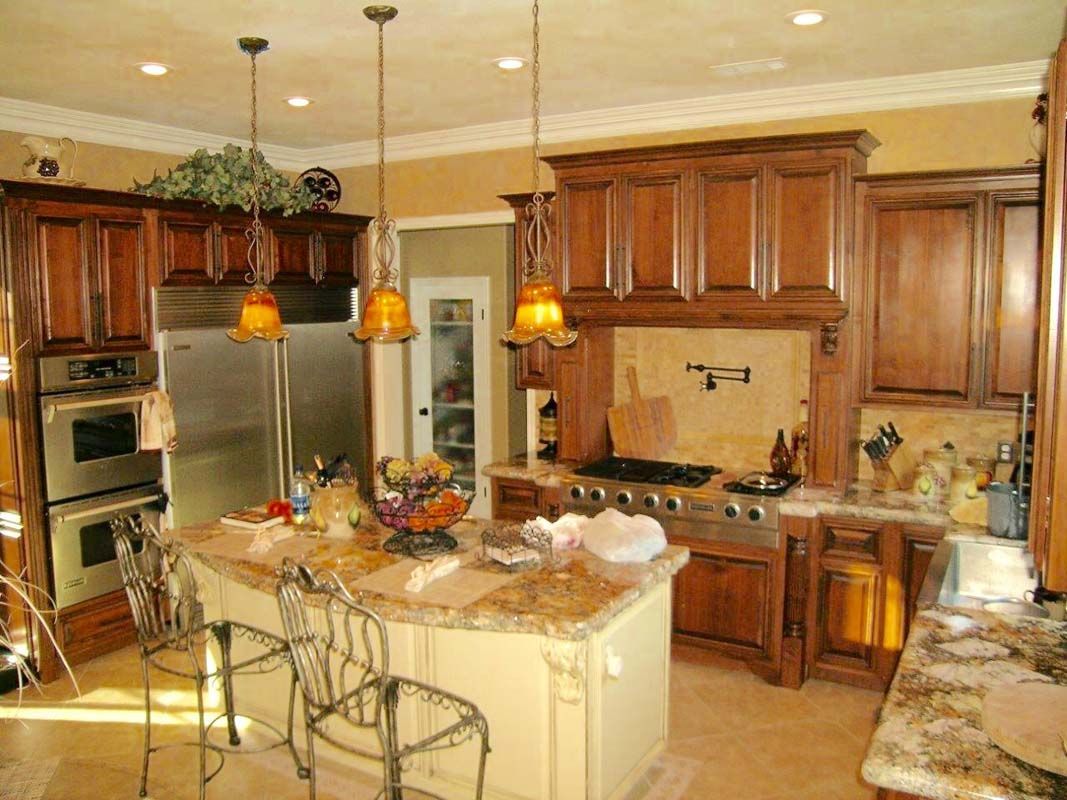 Luxury kitchen with brown cabinets, stainless steel appliances, and a granite countertop island.
