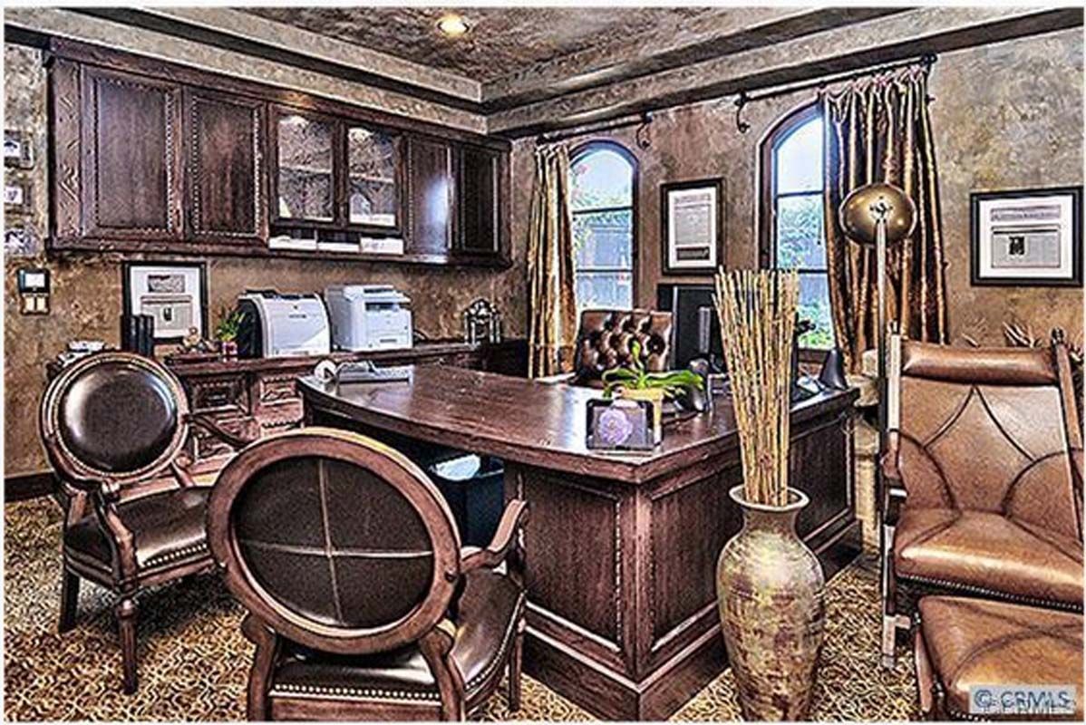 Elegant wood-paneled office with a large desk, leather chairs, and arched windows.