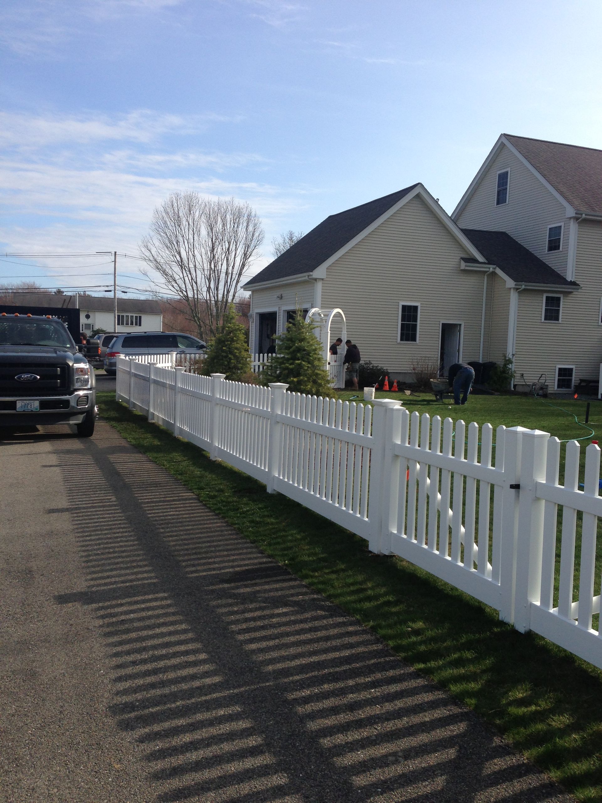A white picket fence is in front of a house