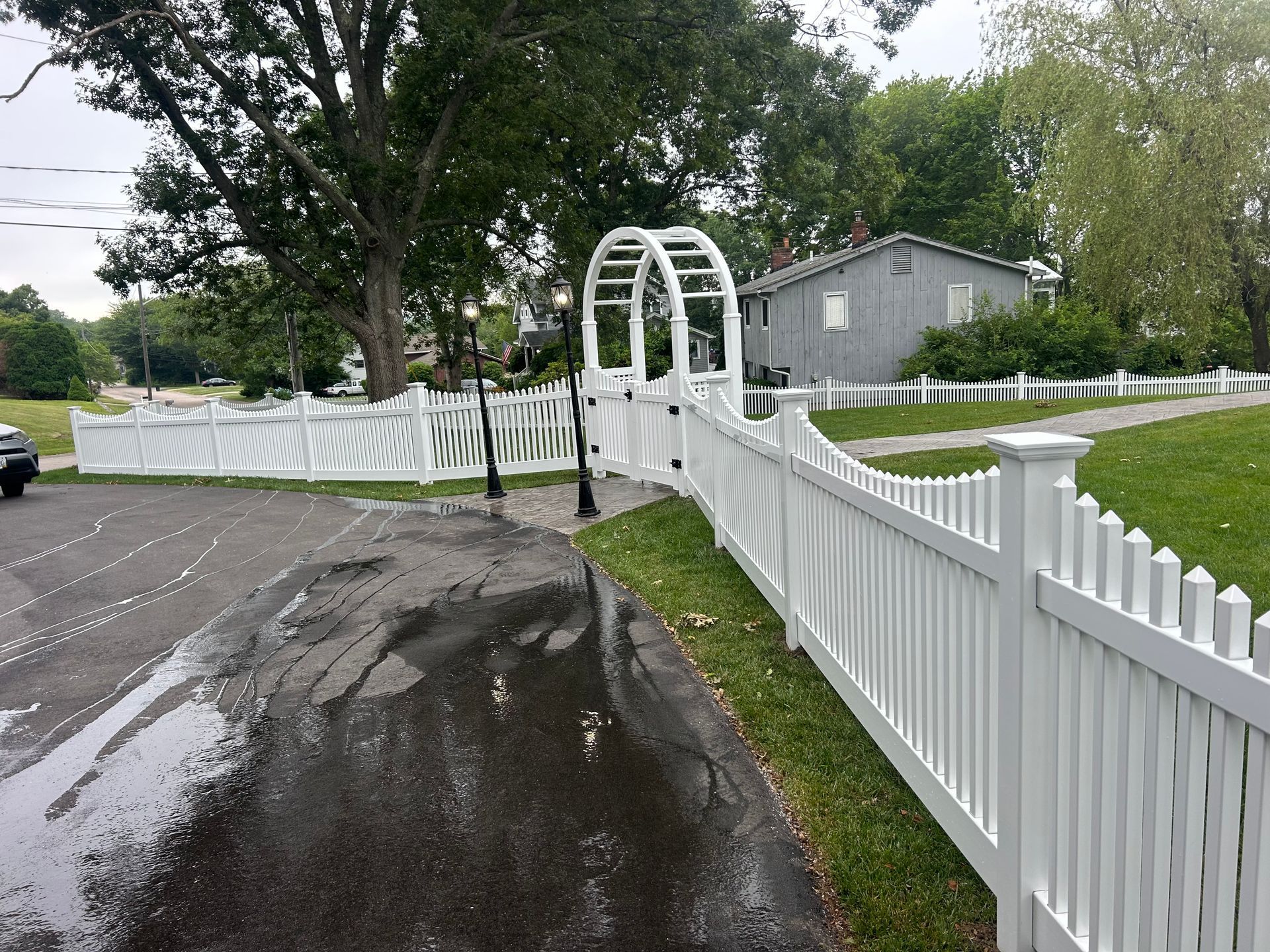 A white picket fence along the side of a road