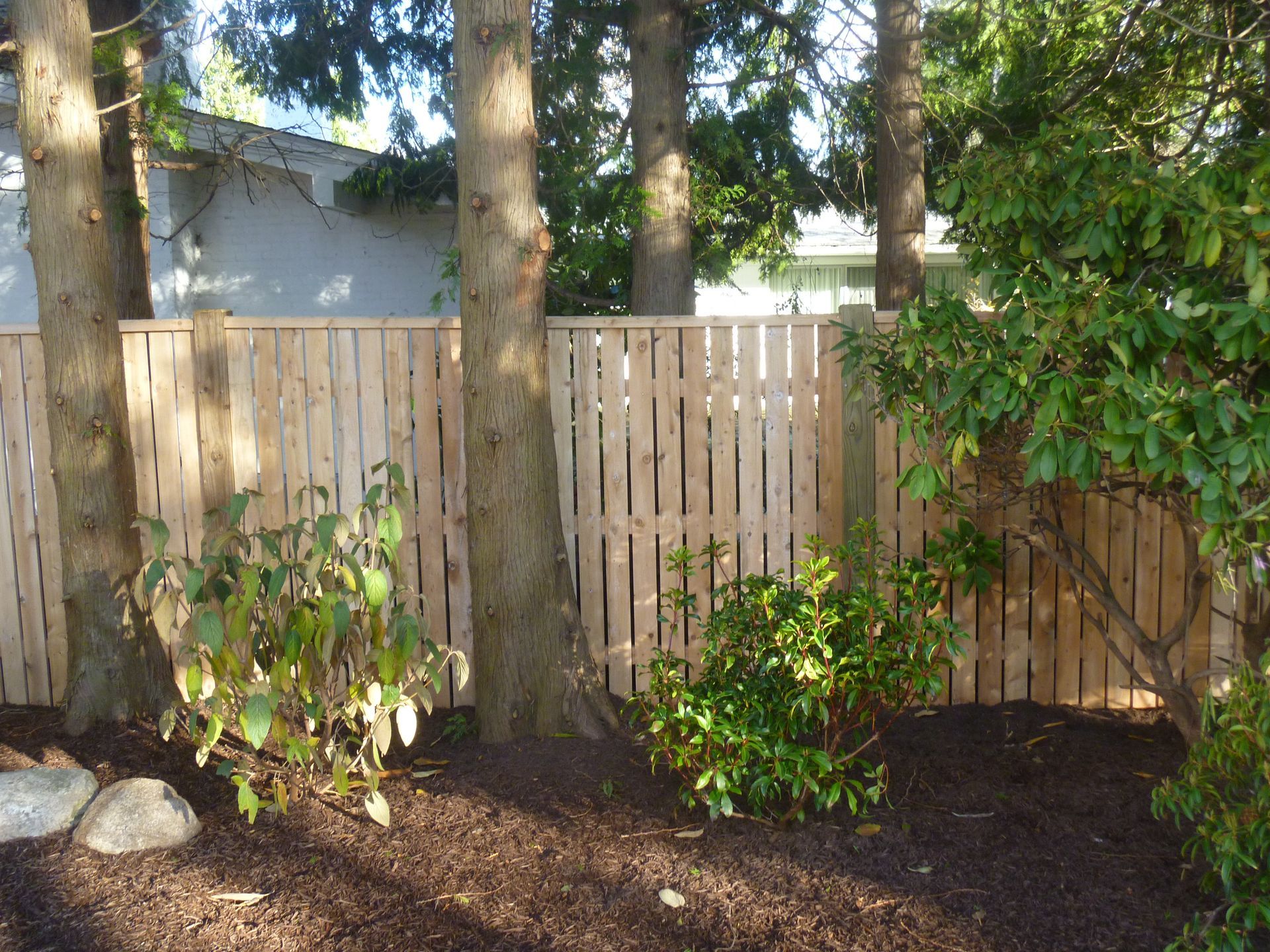 A wooden fence is surrounded by trees and bushes