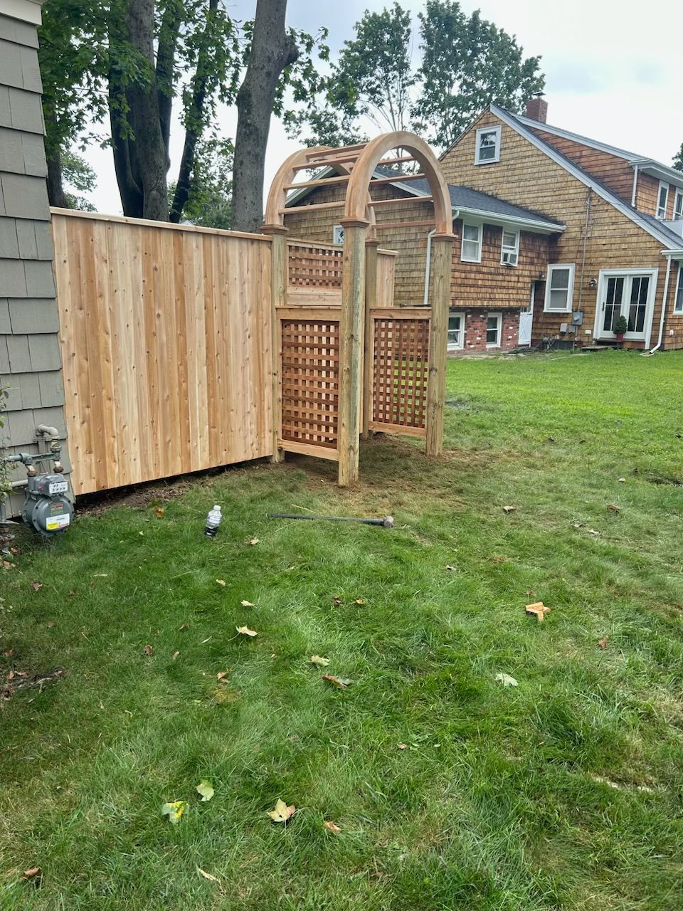 A wooden fence with a gate in the backyard of a house.
