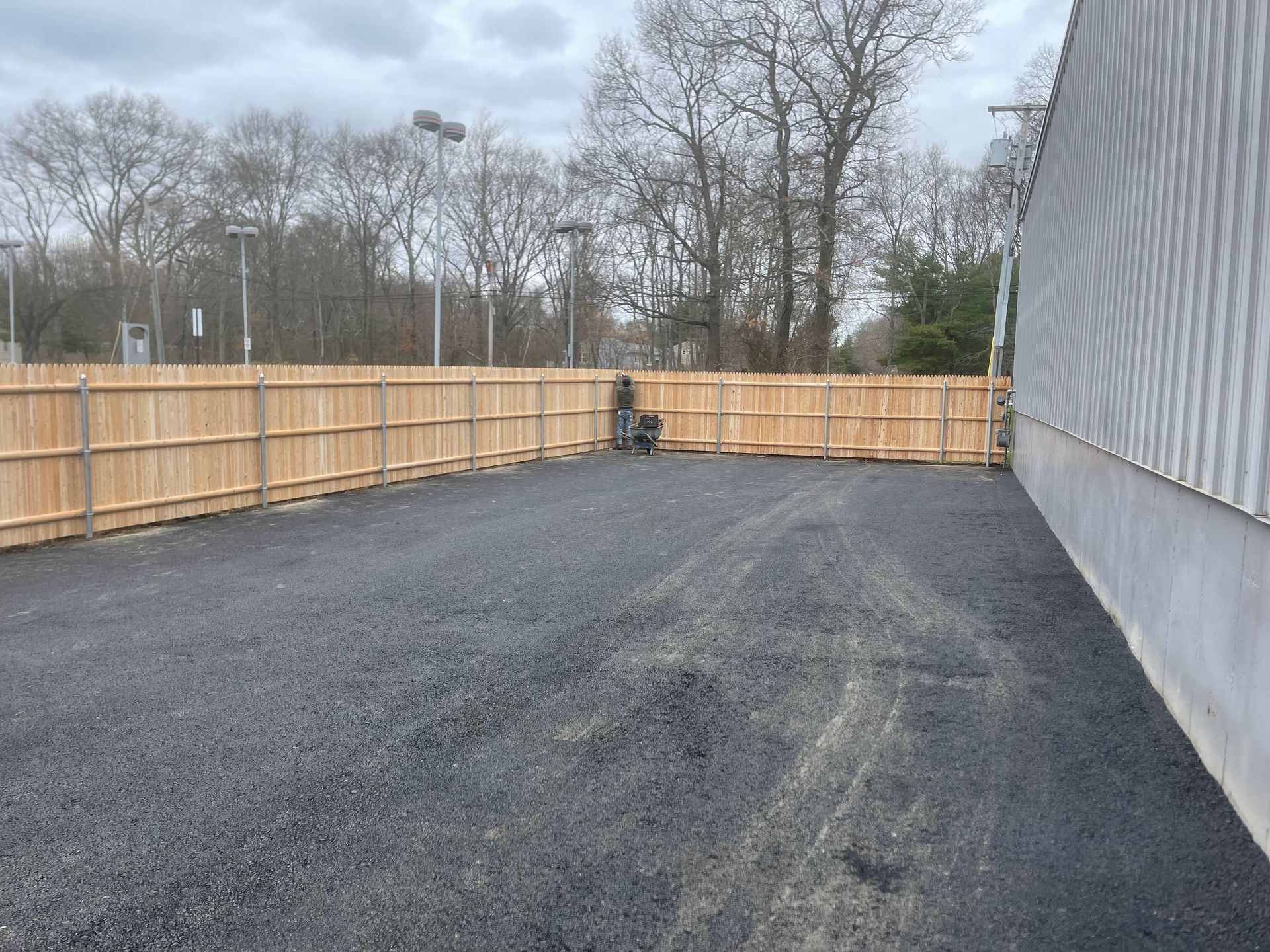 A parking lot with a wooden fence surrounding it
