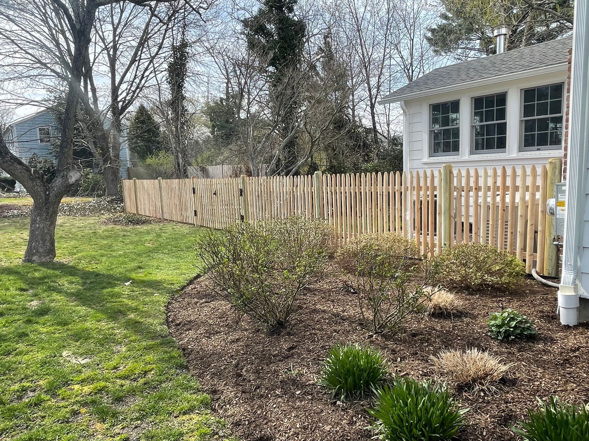There is a wooden fence in the backyard of a house.