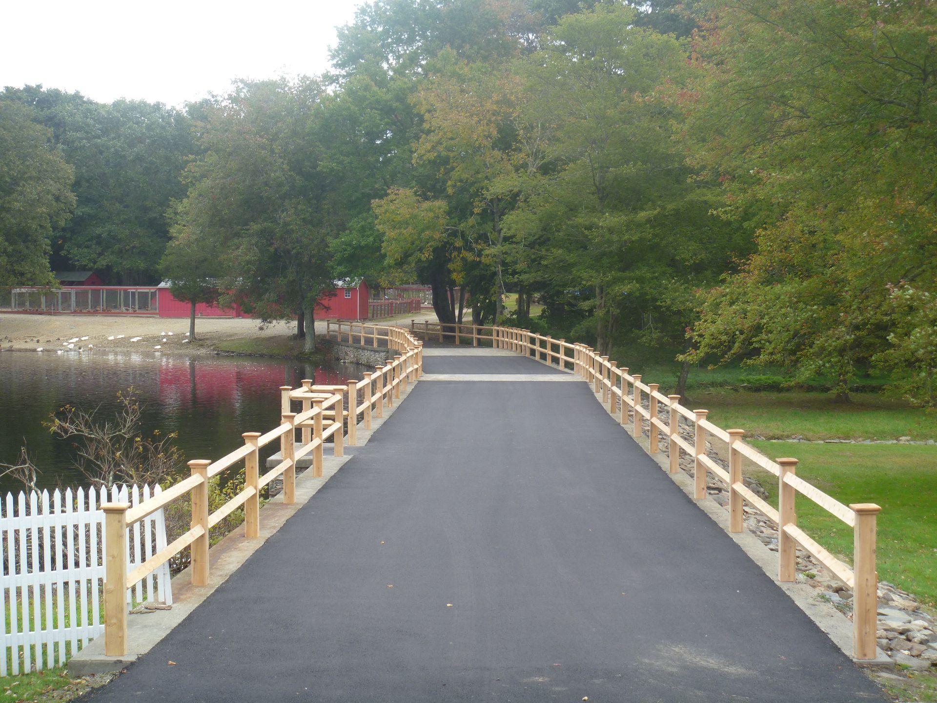 A bridge with a wooden railing over a body of water