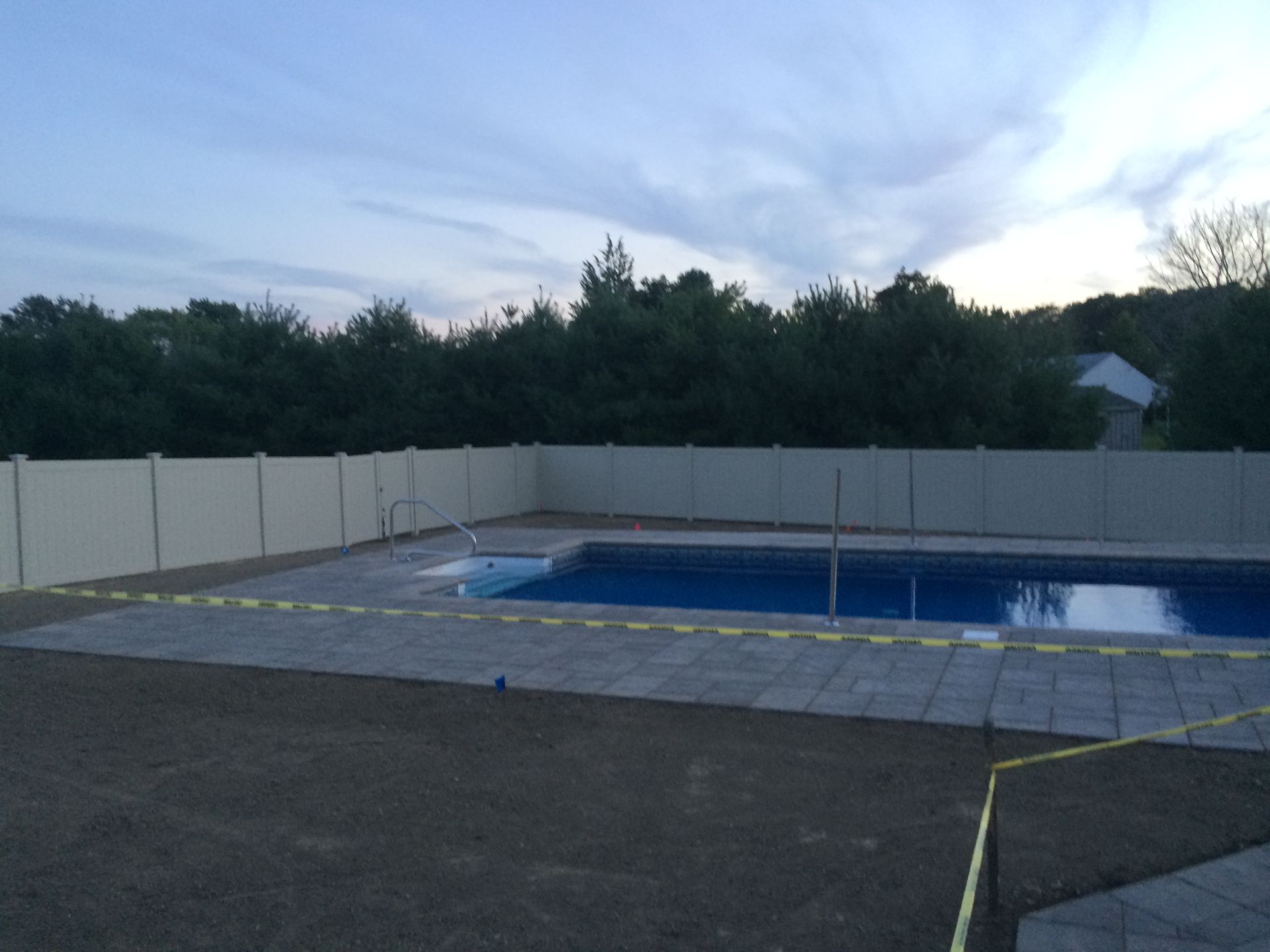 A large swimming pool with a white fence around it