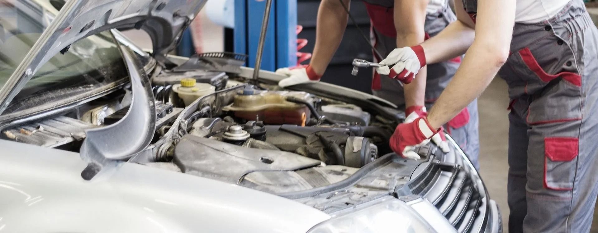 A group of mechanics are working on a car in a garage.