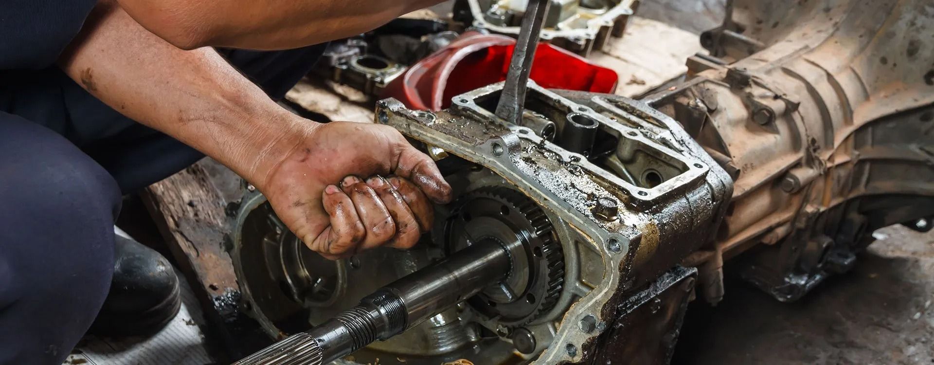 A man is working on a car engine with a wrench.