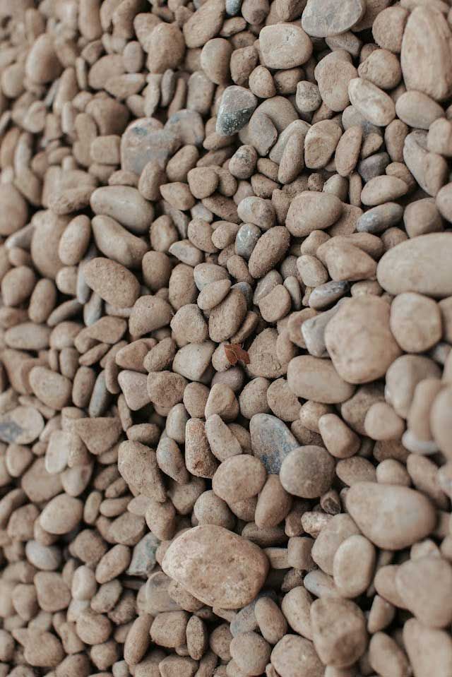 Pile of small, smooth, beige and gray river rocks.