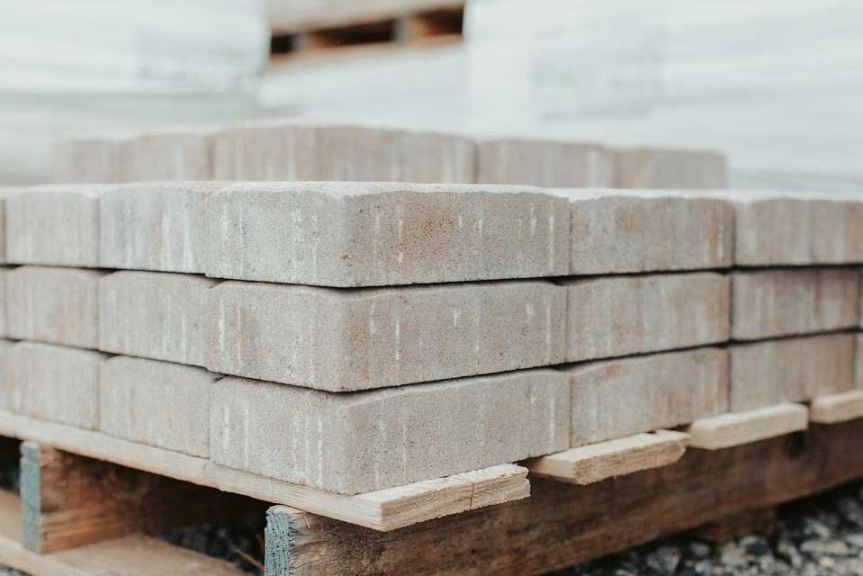 Stack of beige paving stones on a wooden pallet.