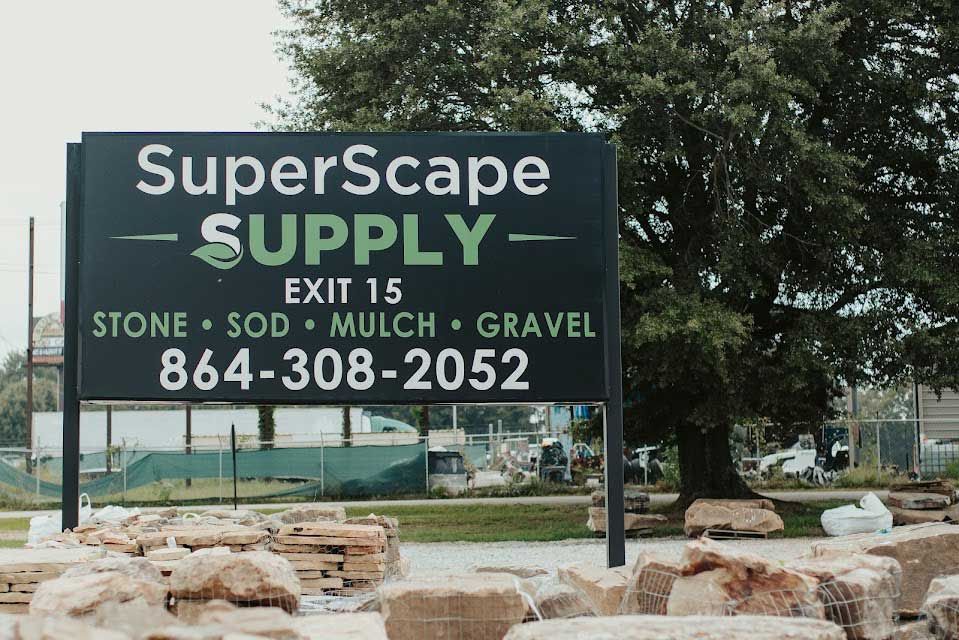 Sign for SuperScape Supply, green and white text on black. Includes phone number and lists stone, sod, mulch, and gravel.