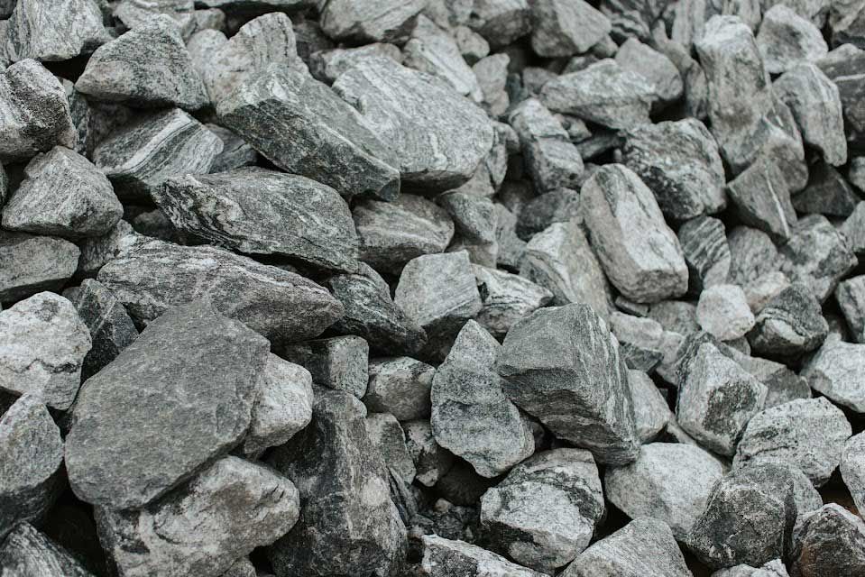Pile of gray, angular rocks; possibly granite or similar material.