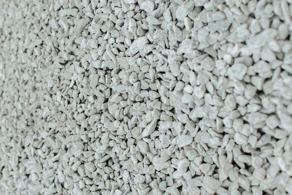 Crushed light gray gravel, filling the frame and textured across the surface.