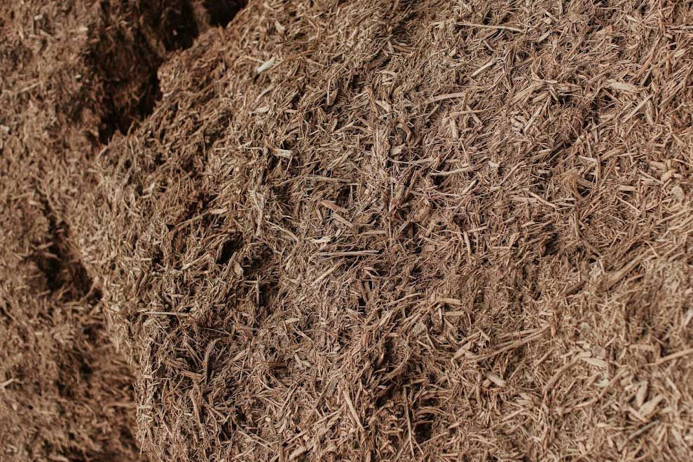 Pile of brown mulch, shredded and textured, filling the frame.