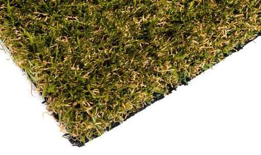 Close-up of artificial turf with green and tan blades, black backing, on white background.