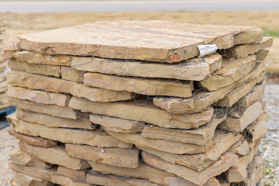 Stack of beige stone pavers held together by wire.