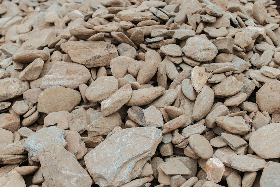 Pile of beige, irregularly shaped stones, likely gravel or landscaping material.