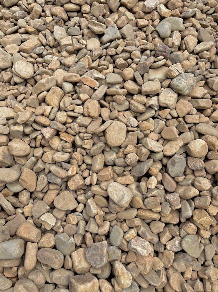 Pile of small, light brown and tan river rocks.