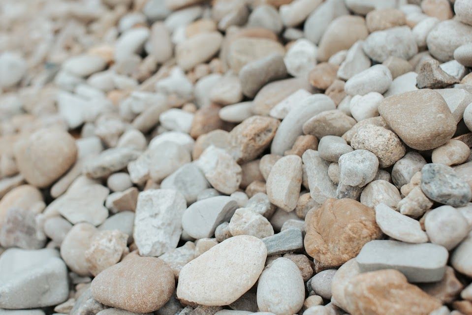 Pile of smooth, beige and grey river rocks.