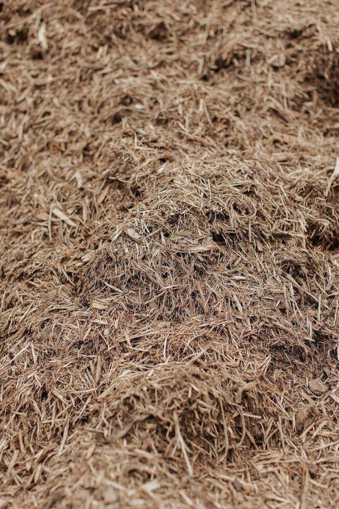 Pile of brown shredded mulch, close-up texture.