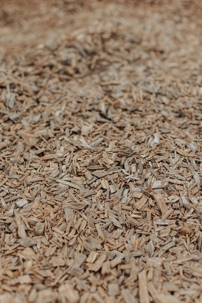 Close-up of a brown wood chip ground covering, textured and layered.
