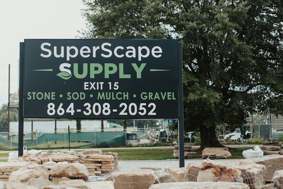 Sign for SuperScape Supply, green and white text, lists stone, sod, mulch, and gravel. Includes phone number, by exit 15.