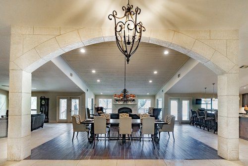 A large dining room with a table and chairs and a chandelier hanging from the ceiling.