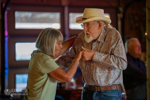 A man in a cowboy hat is dancing with a woman.