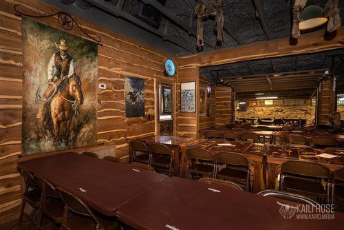 There is a painting of a man riding a horse on the wall.