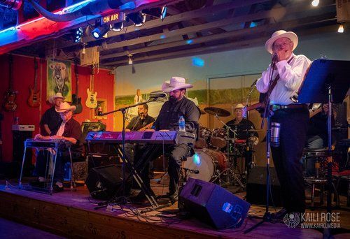 A group of men are playing instruments on a stage in a room.