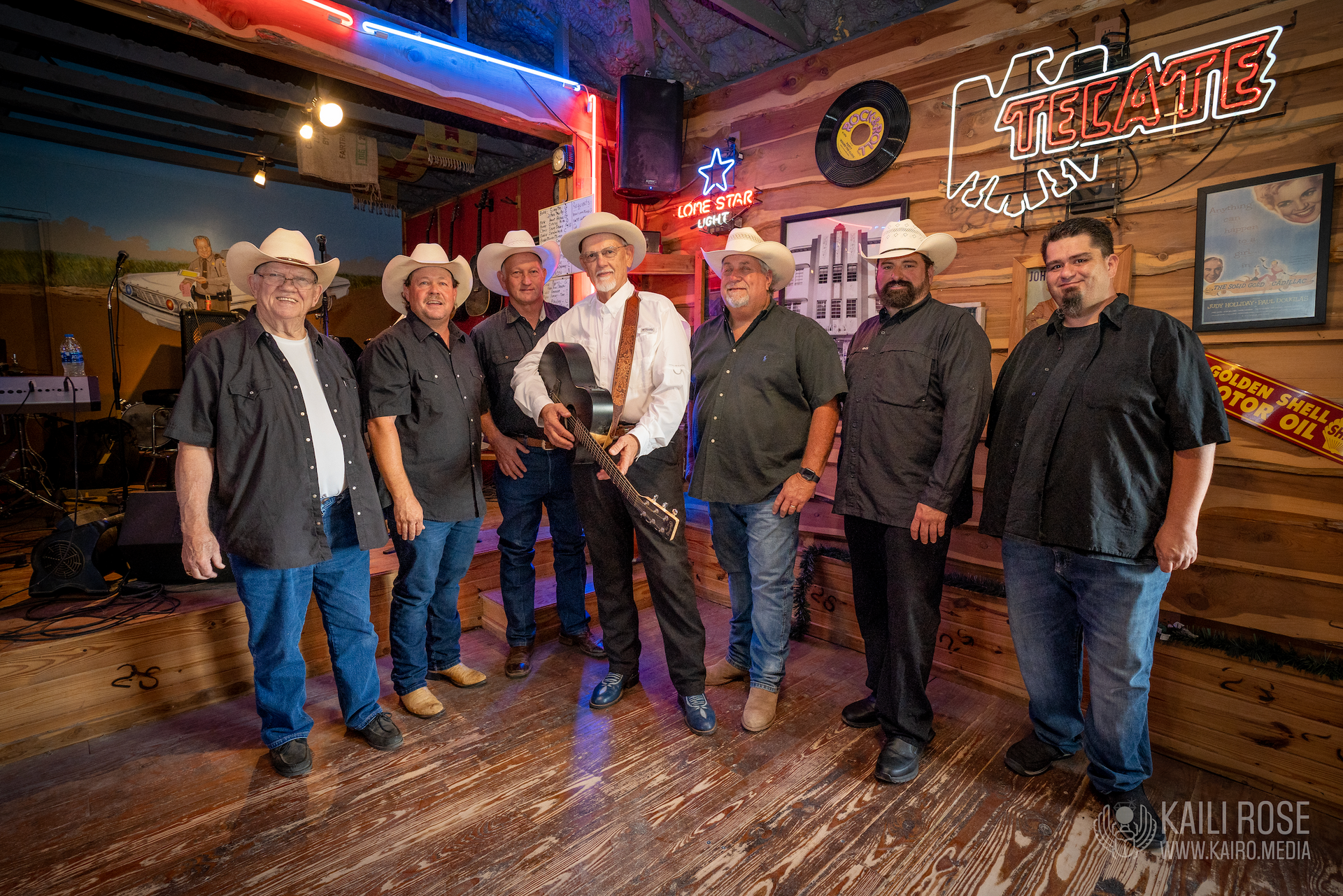 A group of men in cowboy hats are standing next to each other in a room.