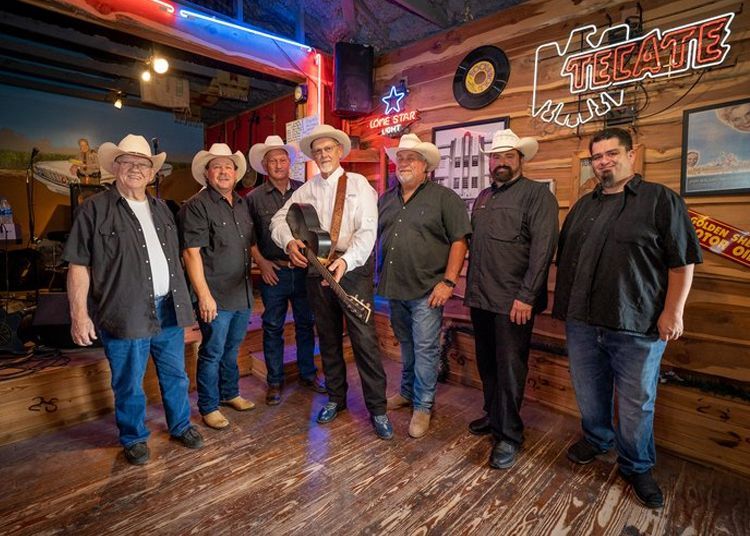 A group of men in cowboy hats are standing next to each other in a room.