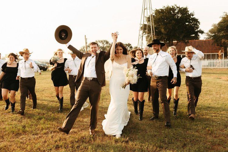 A bride and groom are walking with their wedding party