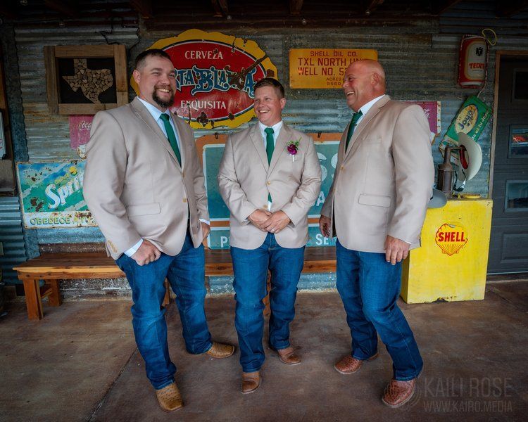 A group of men standing next to each other in front of a sign that says shell