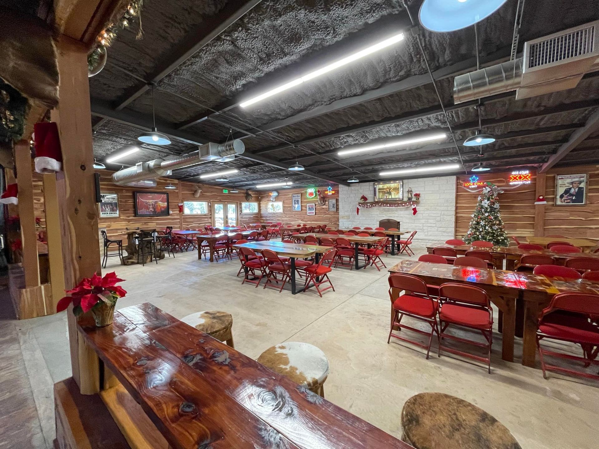 A large room filled with tables and chairs and a christmas tree.