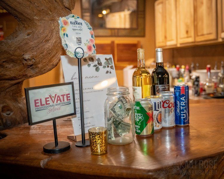 A bar with a sign that says `` elevate '' and a jar of money on it.