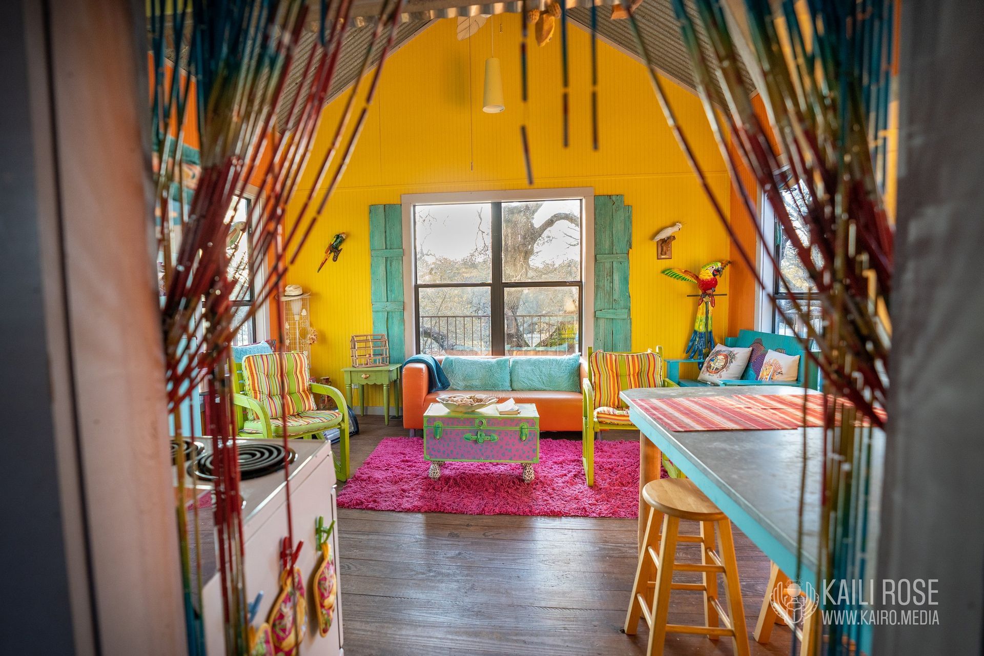 A living room with yellow walls and a table and chairs