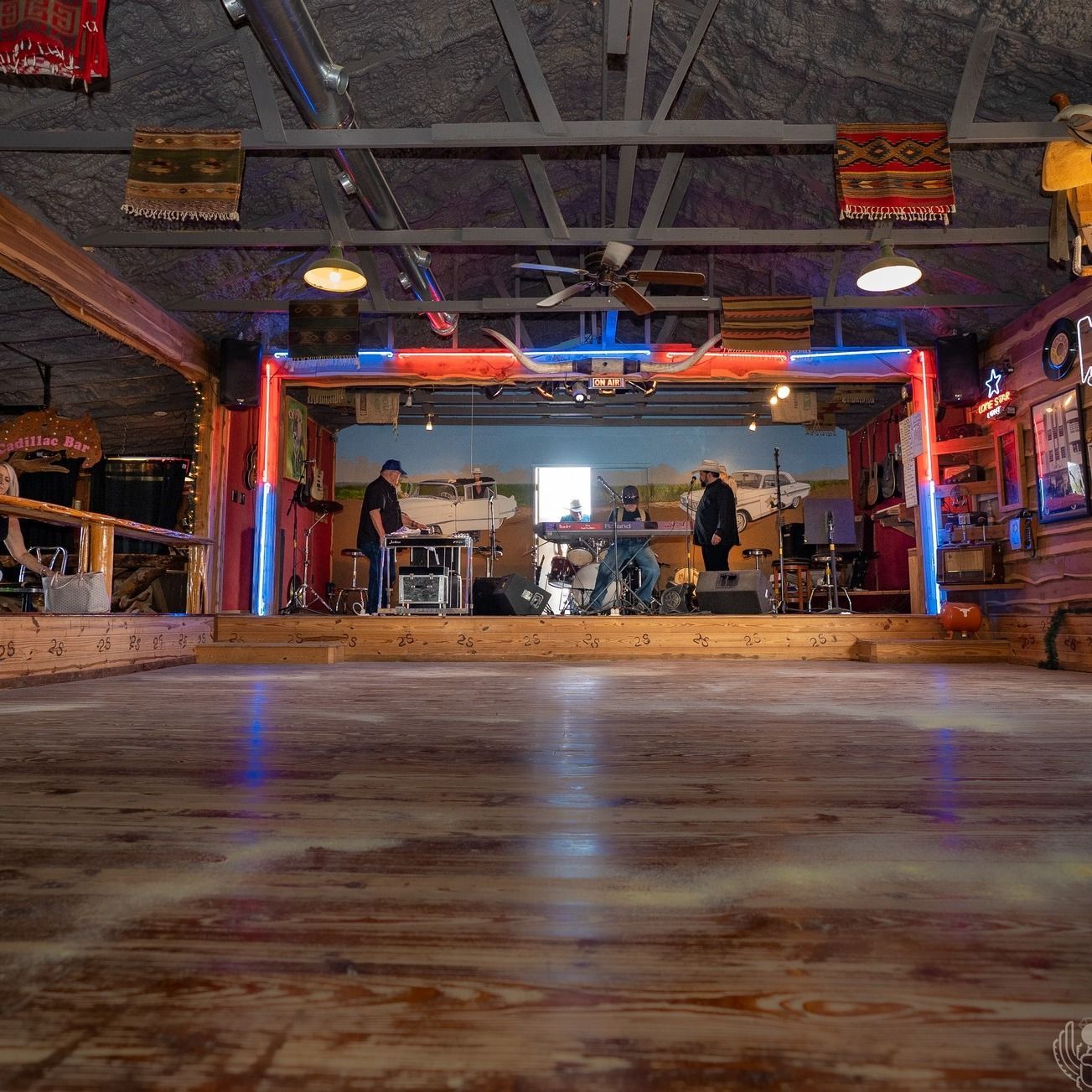 A large room with a wooden floor and a stage in the middle of it.