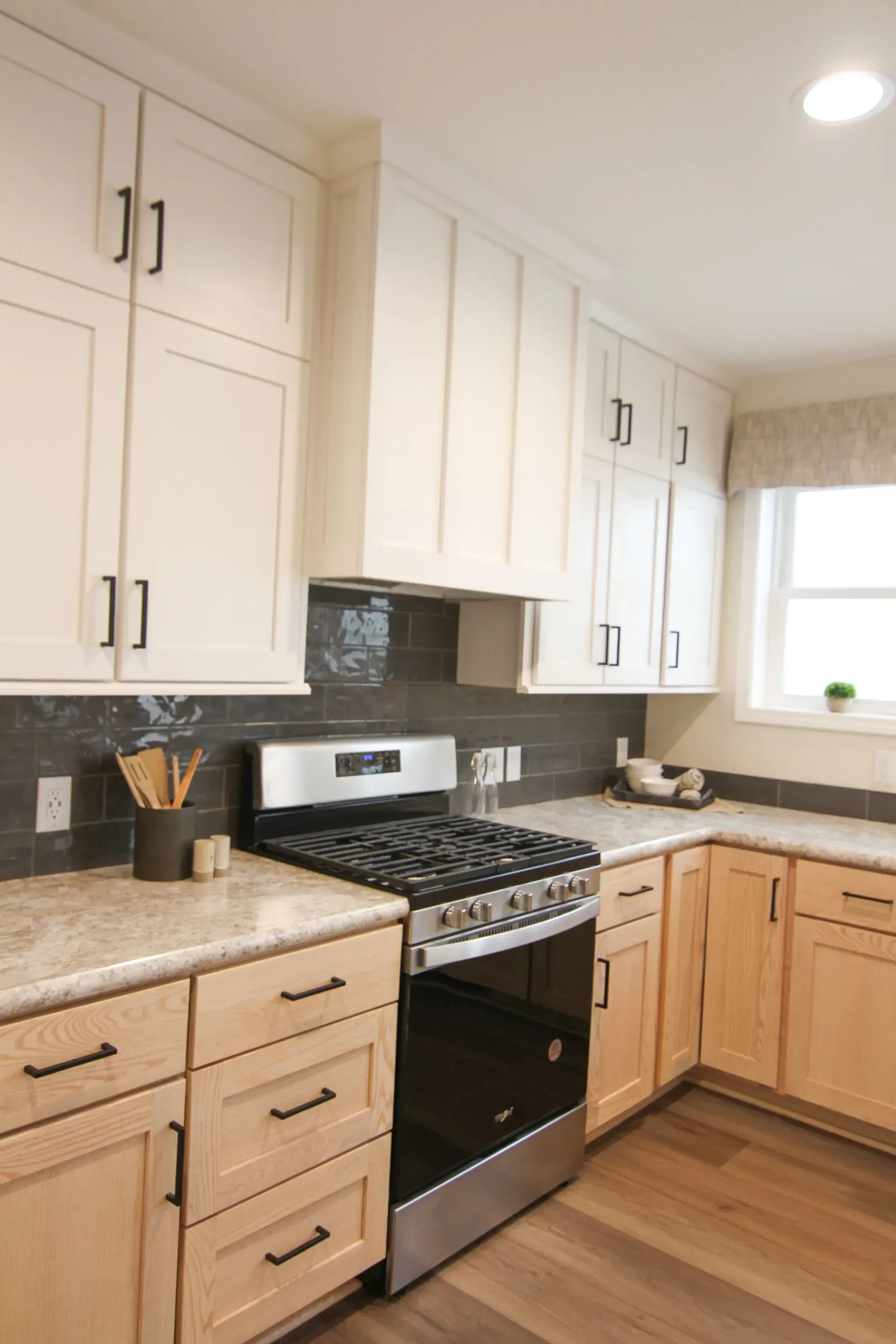 Kitchen with light cabinets, stainless steel appliances, and wooden flooring.