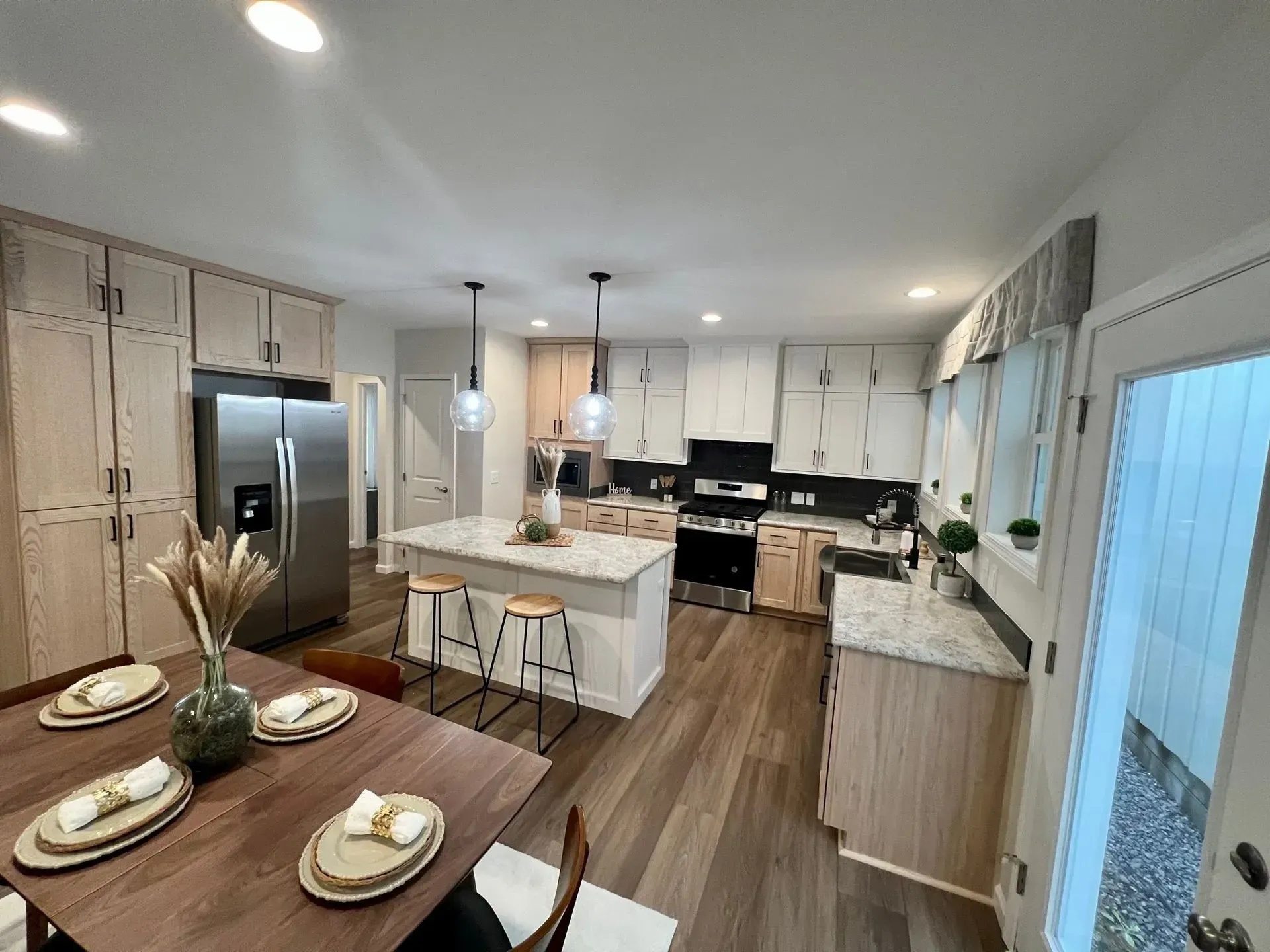 Modern kitchen with island, stainless steel appliances, and wood flooring.