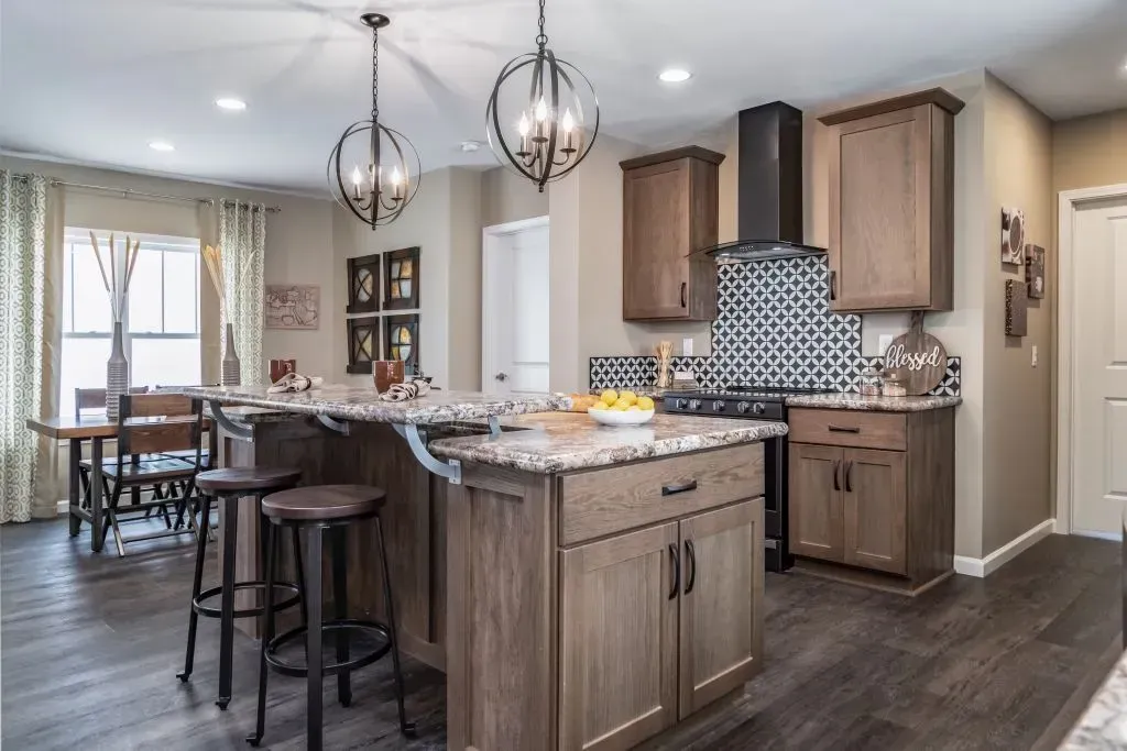 Kitchen with island, dark wood cabinets, granite countertops, and decorative light fixtures.