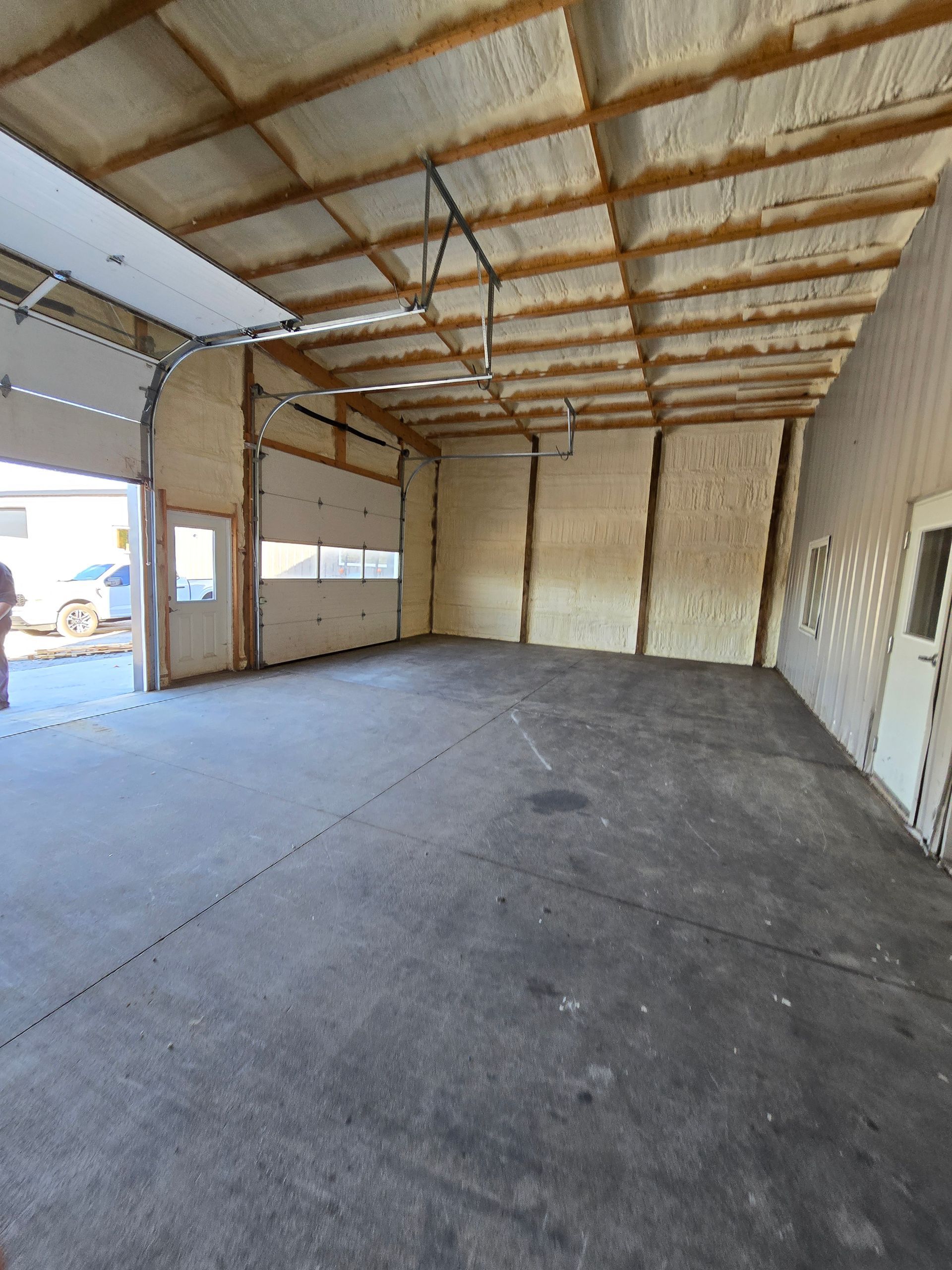 A large empty garage with a garage door open