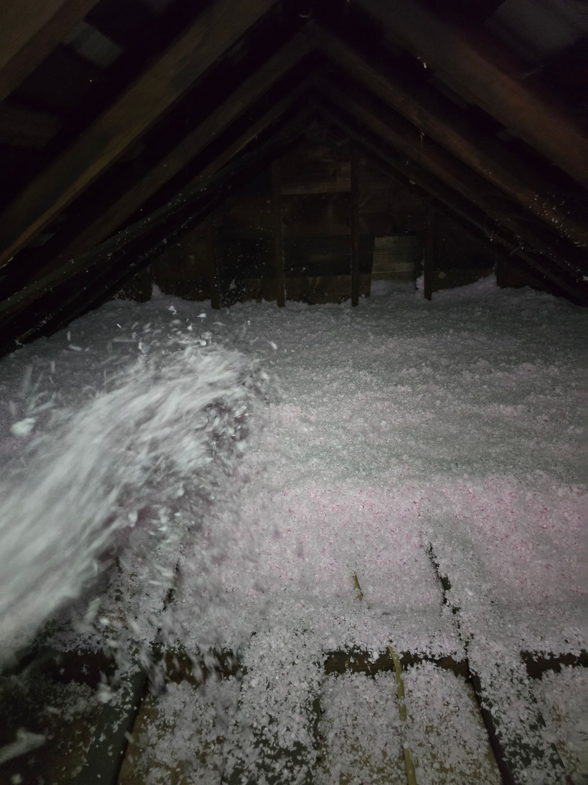 There is a lot of insulation in the attic of a house.