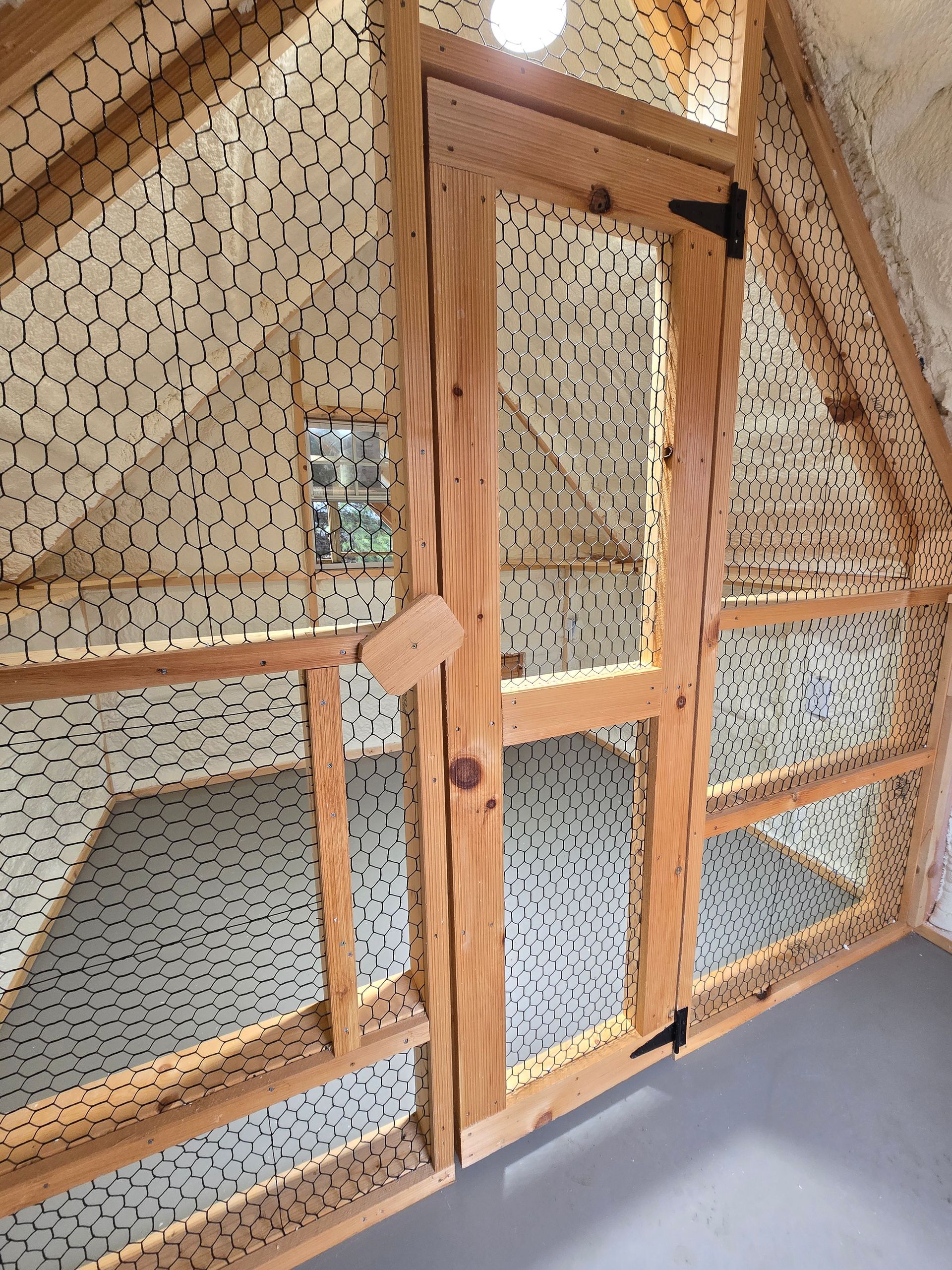 A wooden chicken coop with a glass door