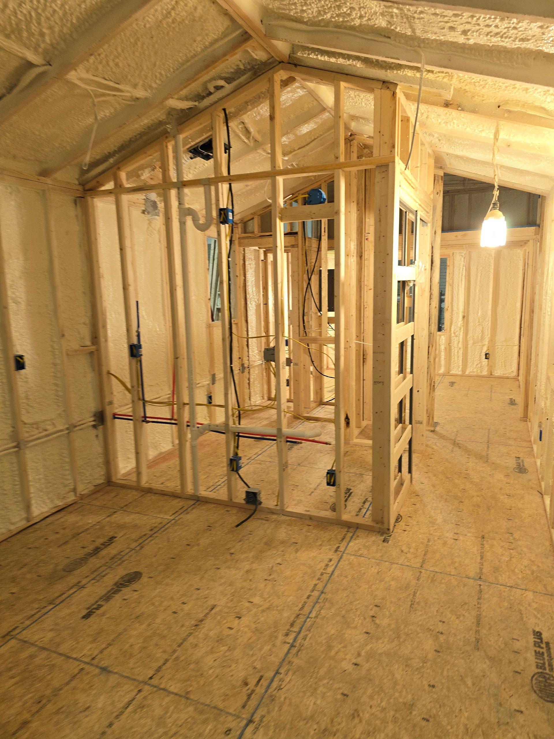 A room with a lot of wooden walls and a light hanging from the ceiling.