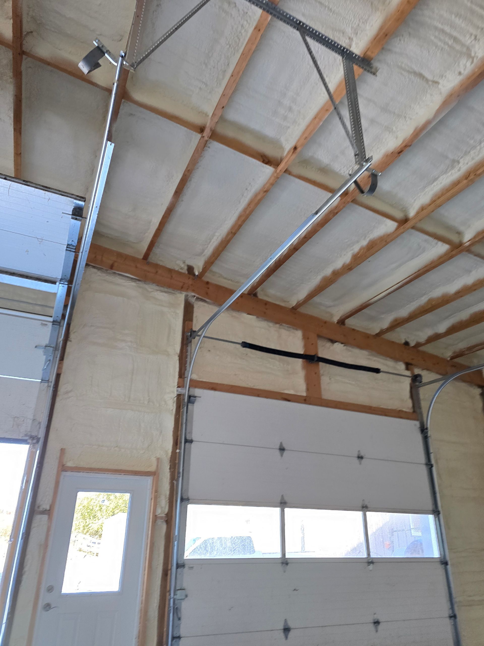A garage door with a ceiling that is covered in foam.