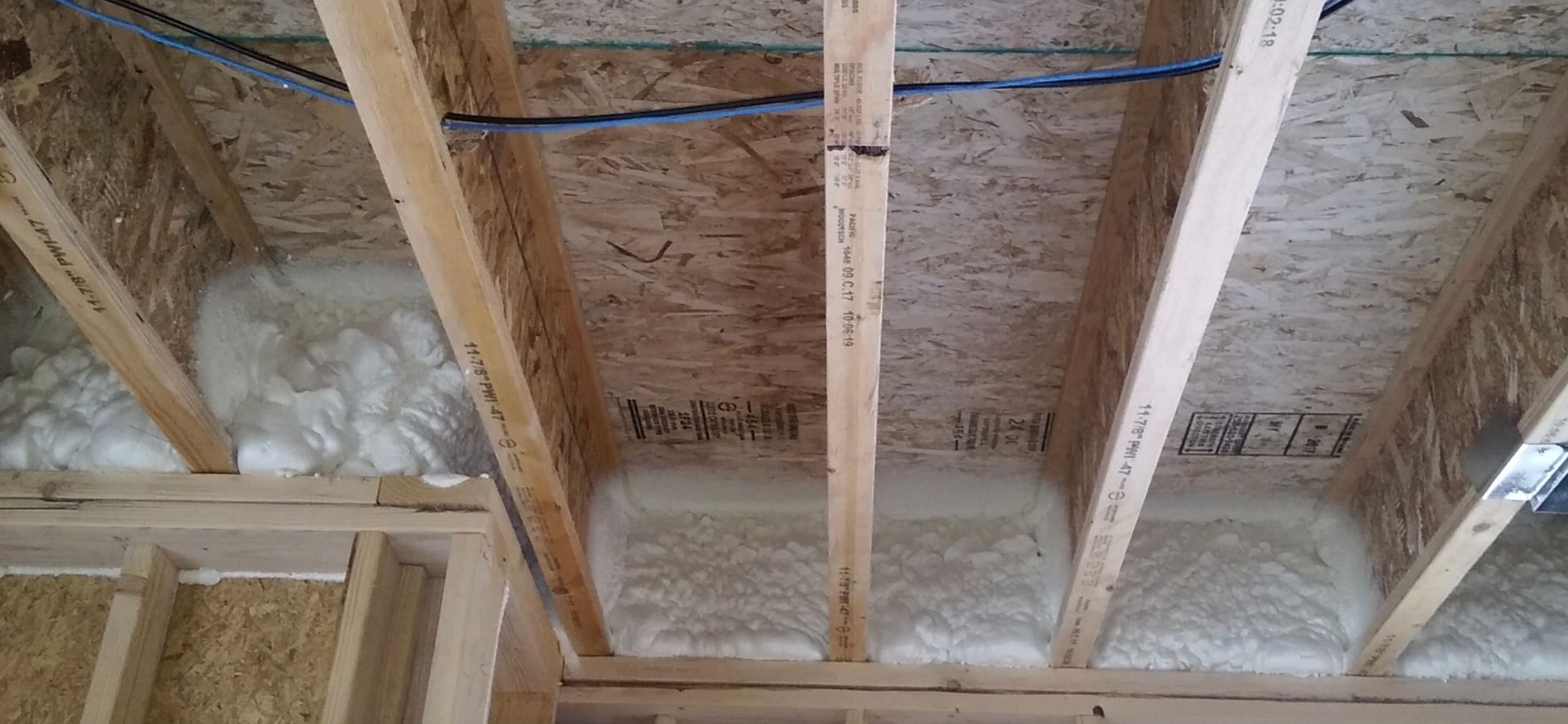 The ceiling of a house is being built and there is a lot of insulation in the ceiling.
