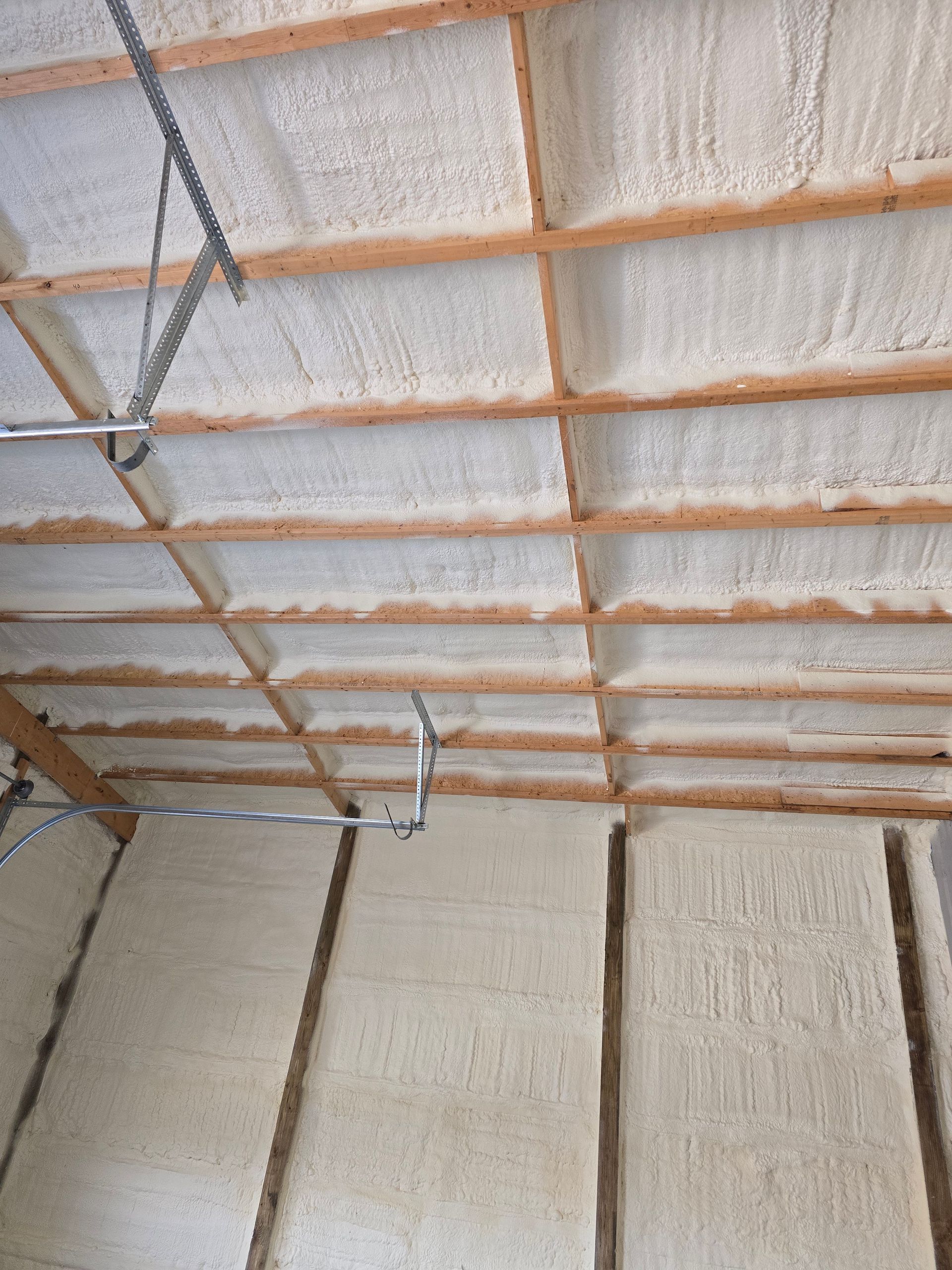 A ceiling with a lot of foam on it and wooden beams.